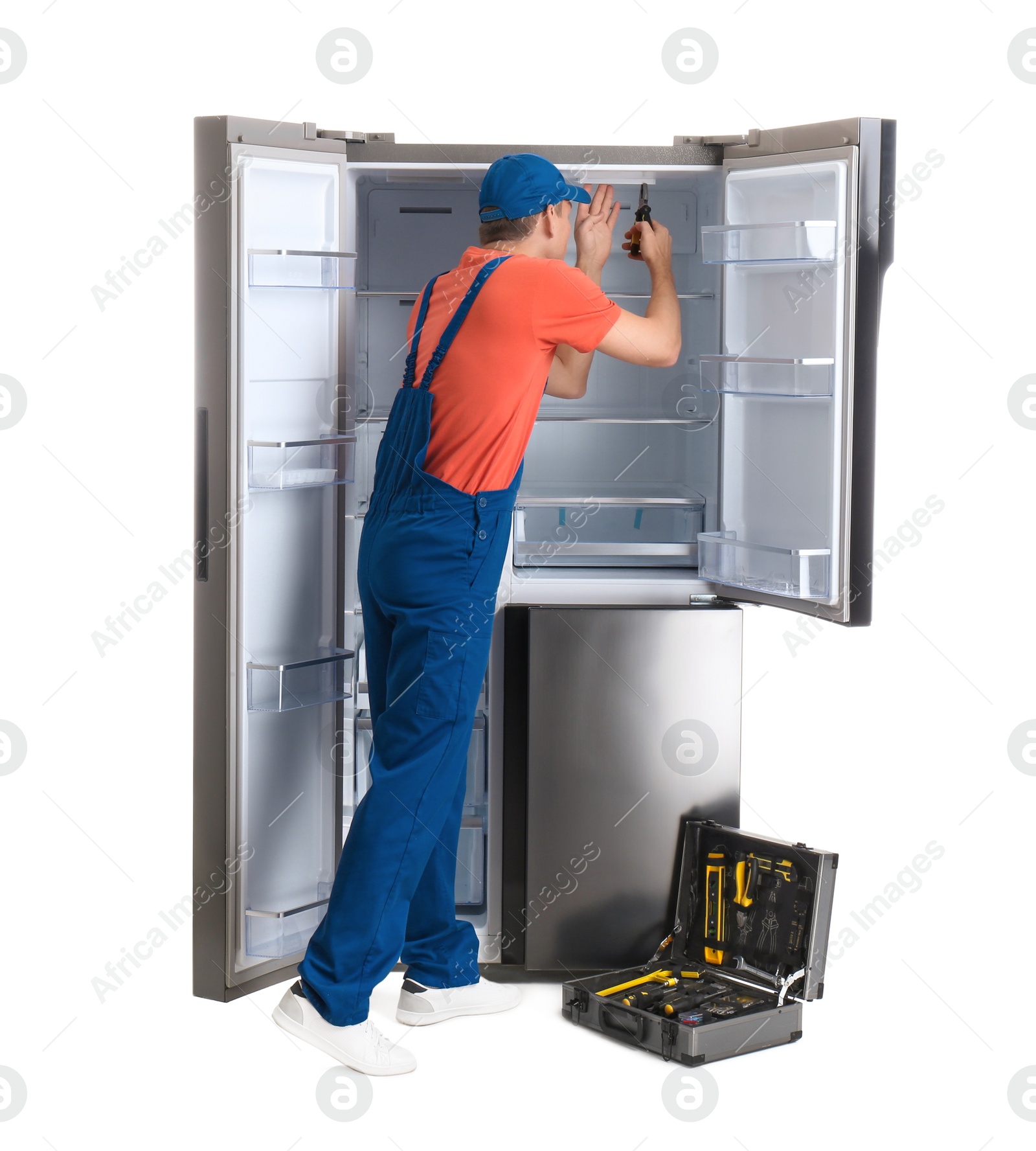 Photo of Male technician repairing refrigerator on white background