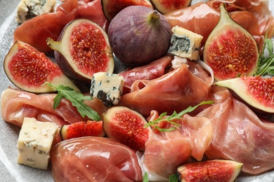 Photo of Delicious ripe figs, prosciutto and cheese, closeup