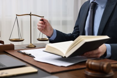 Photo of Lawyer working with documents at wooden table indoors, closeup