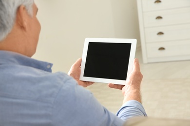 Photo of Man using video chat on tablet at home, closeup. Space for text