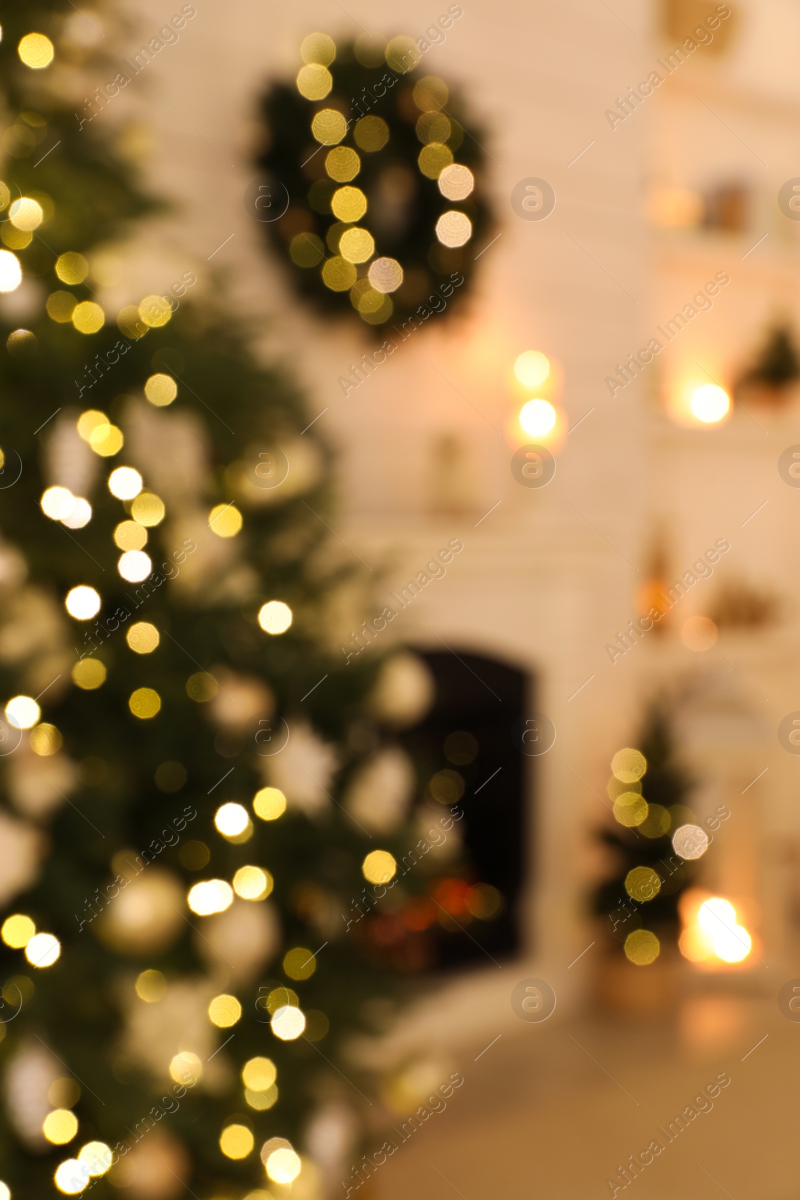 Photo of Blurred view of decorated Christmas tree and fireplace in room