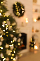 Photo of Blurred view of decorated Christmas tree and fireplace in room