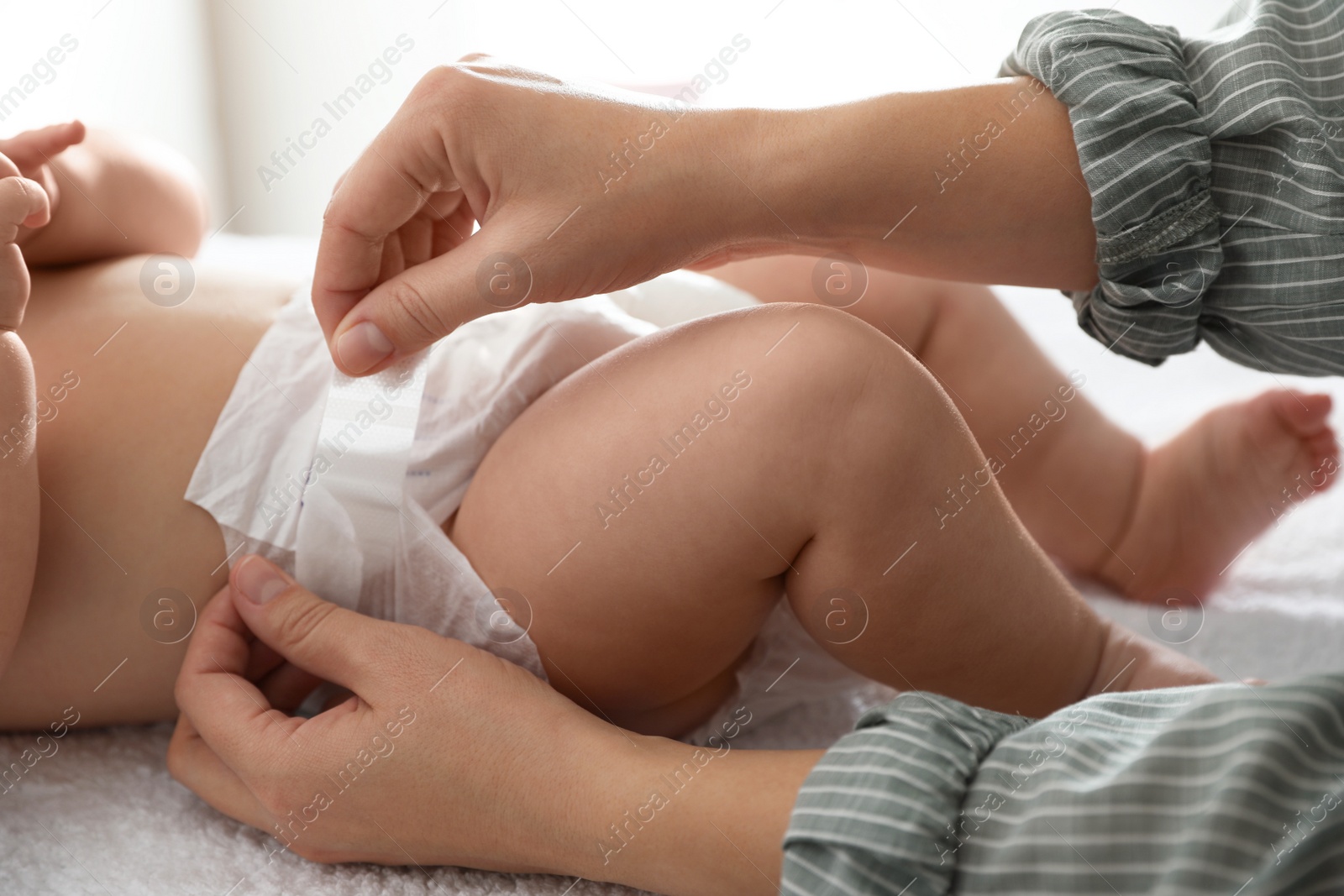 Photo of Mother changing her baby's diaper on table, closeup