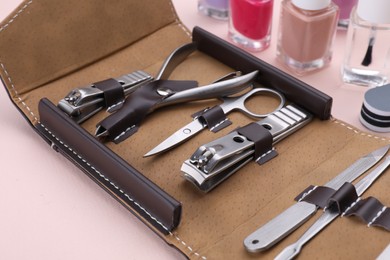 Photo of Kit of pedicure tools on beige background, closeup