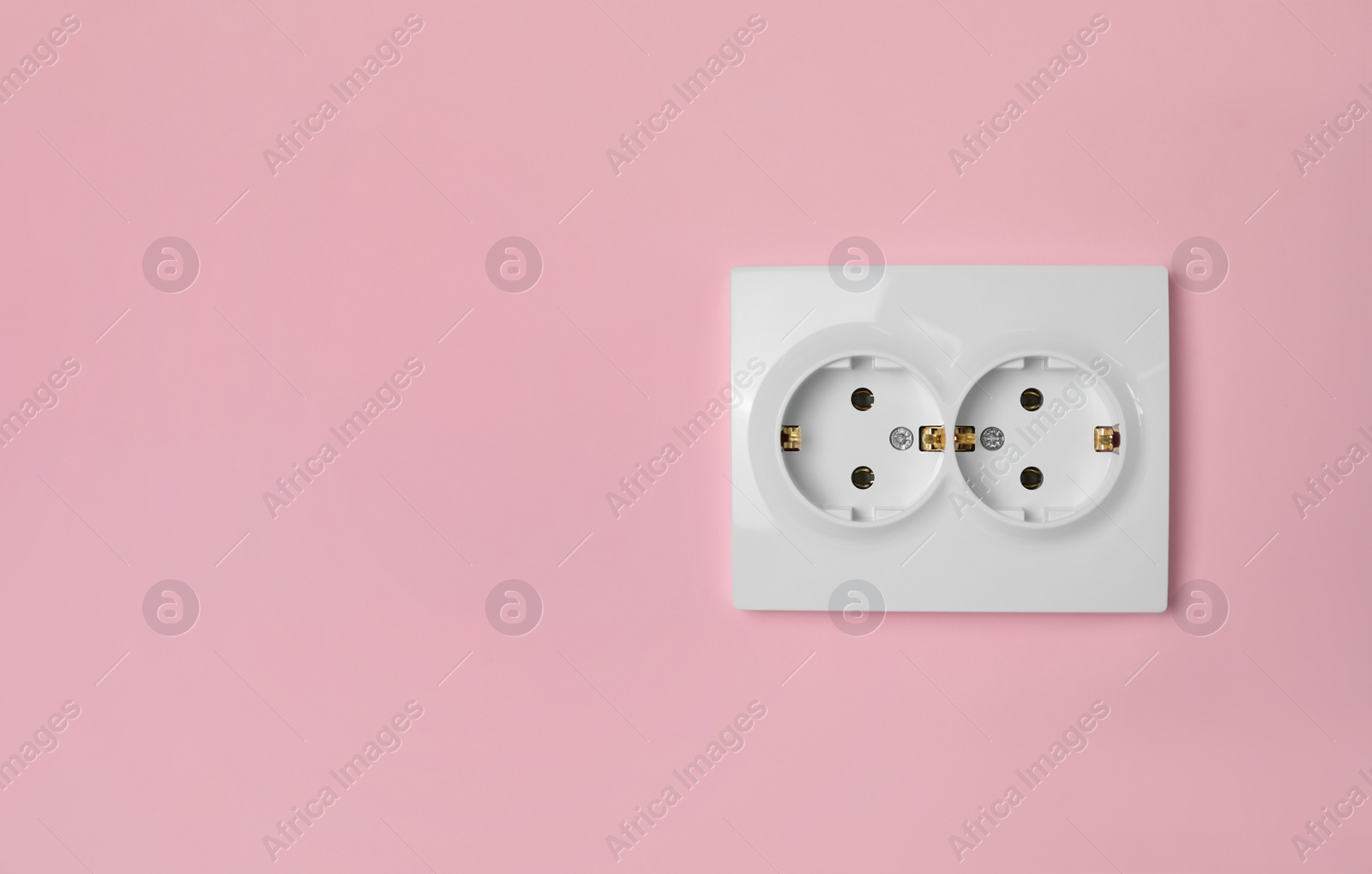 Photo of Double power socket on pink wall, space for text. Electrical supply