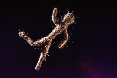 Image of Voodoo doll with pins on dark background