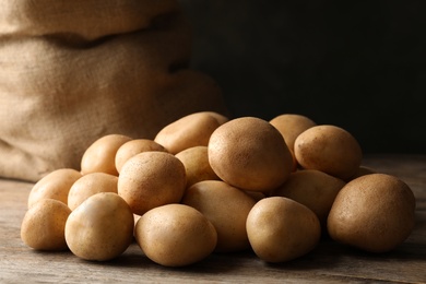 Raw fresh organic potatoes on wooden table