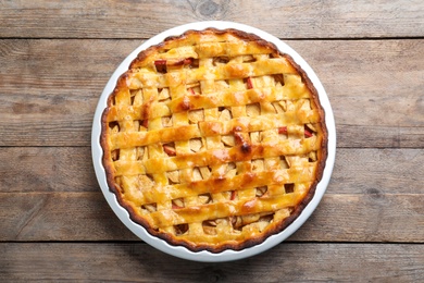 Photo of Traditional apple pie on wooden table, top view