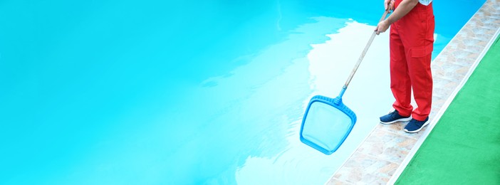 Male worker cleaning outdoor pool with scoop net, space for text. Banner design