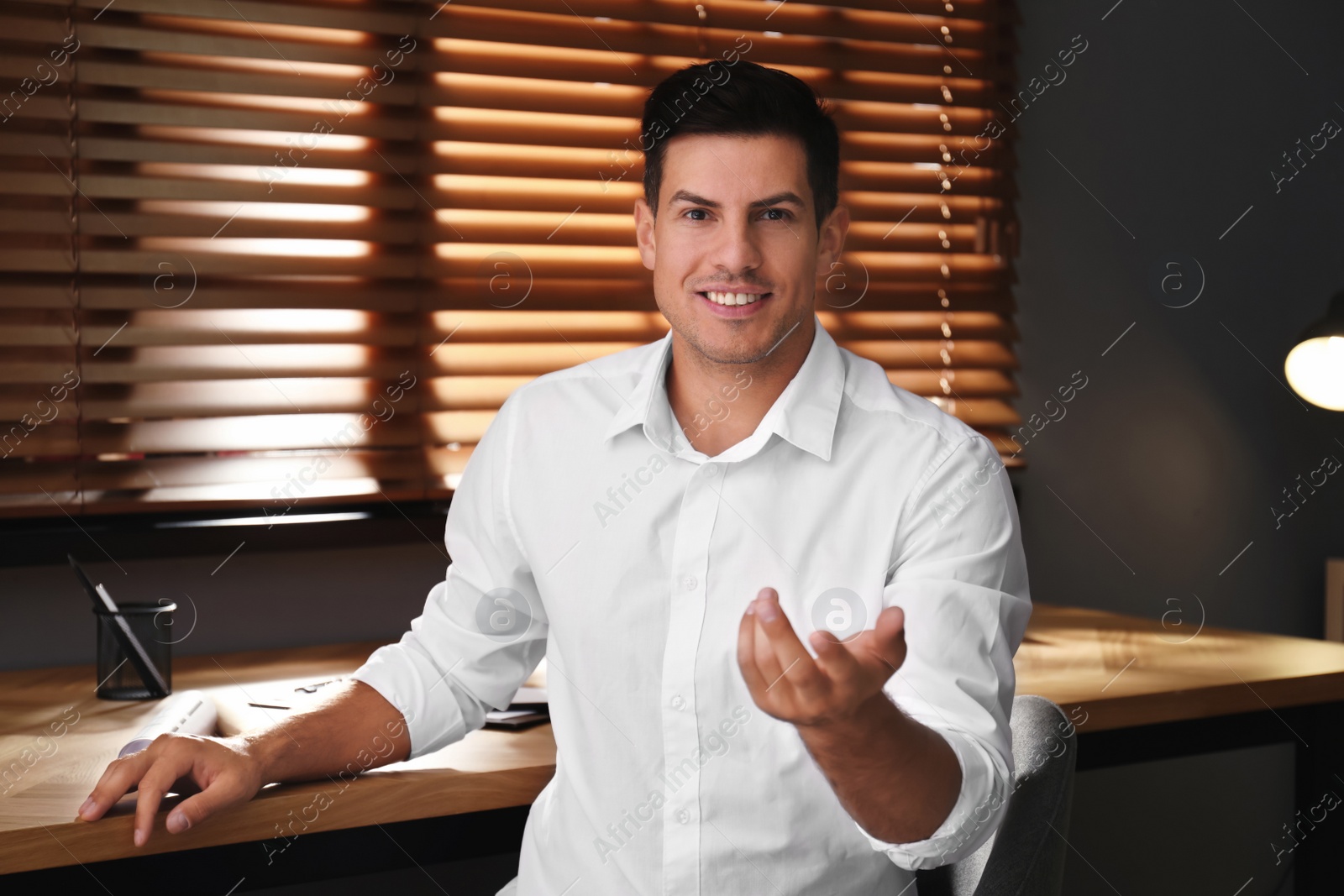 Photo of Man talking to his coworkers through video conference indoors, view from webcam