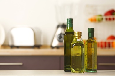 Photo of Bottles of oil on table against blurred background. Space for text