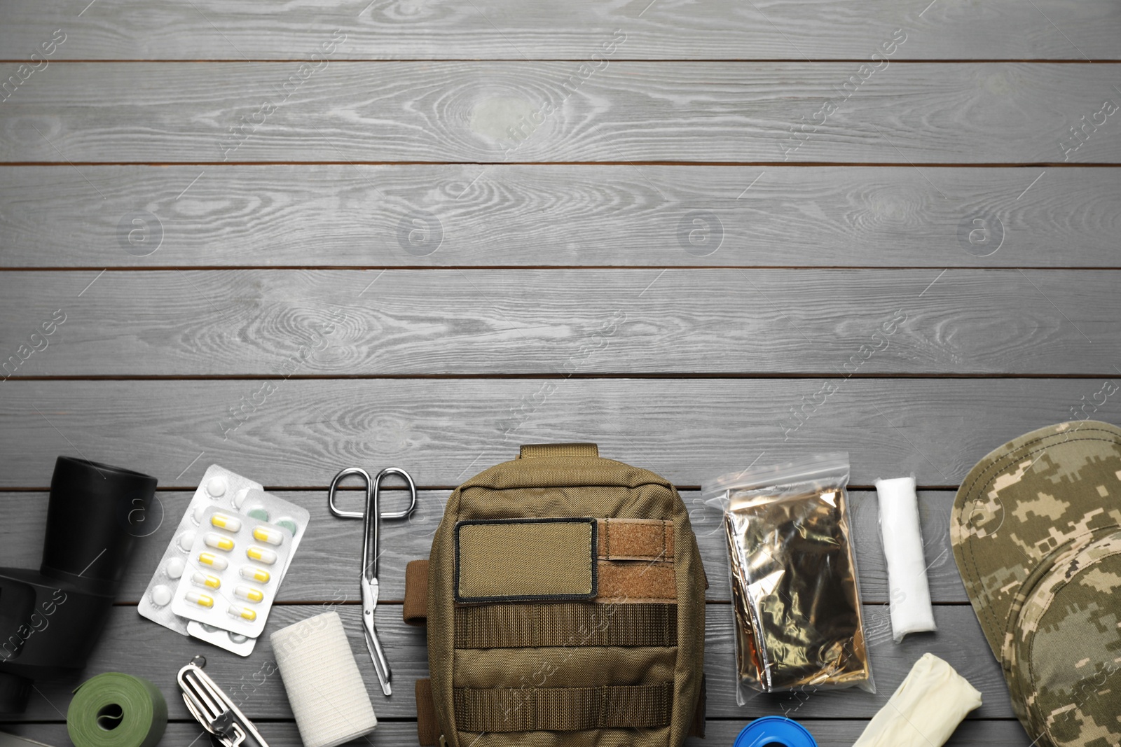 Photo of Military first aid kit on wooden table, flat lay. Space for text