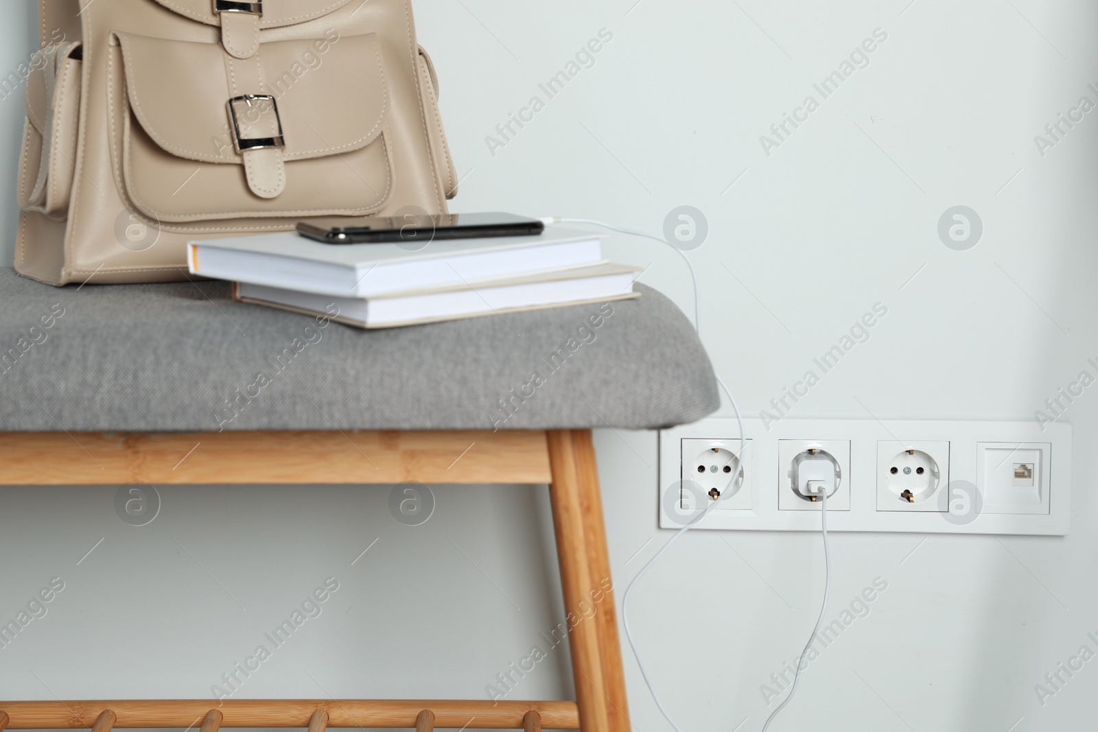 Photo of Electric power outlet sockets with charger on white wall