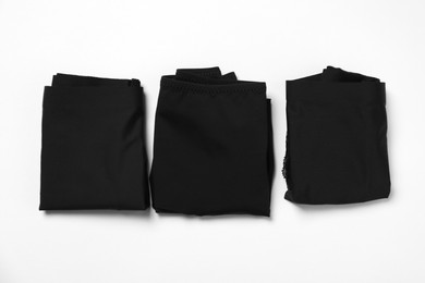 Photo of Stylish folded black women's underwear on white background, flat lay