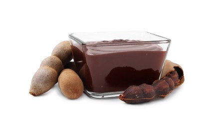 Photo of Bowl of tasty tamarind sauce and fresh pods isolated on white