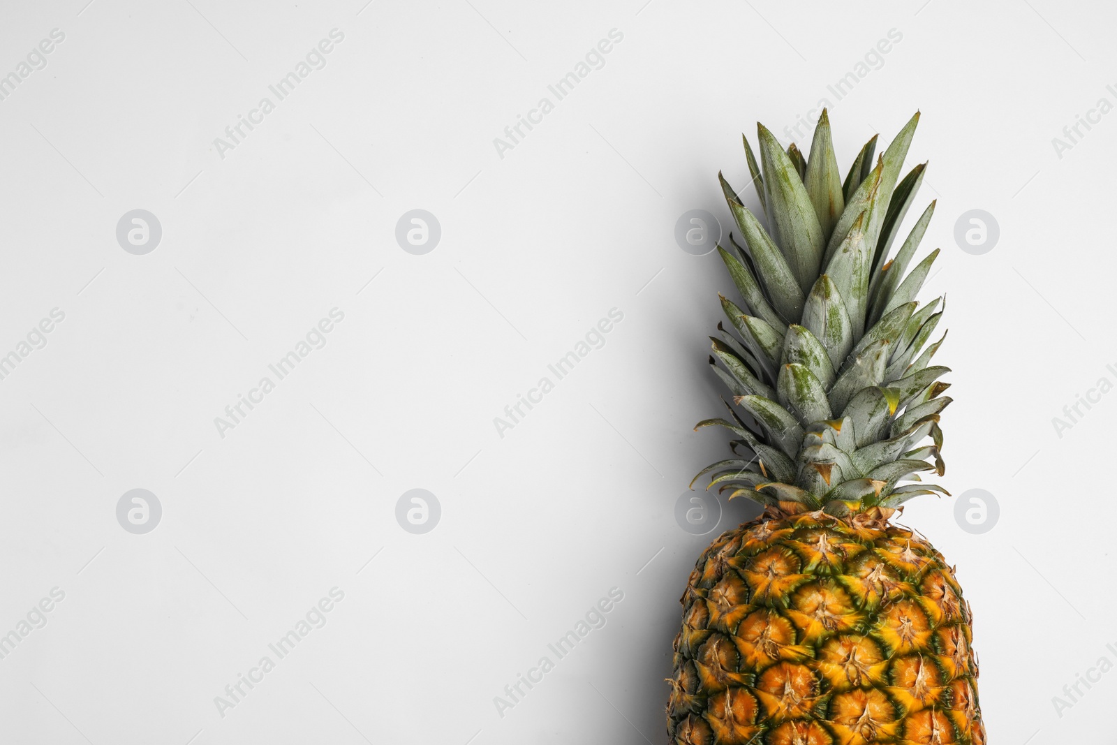 Photo of Tasty whole pineapple with leaves on white background, top view