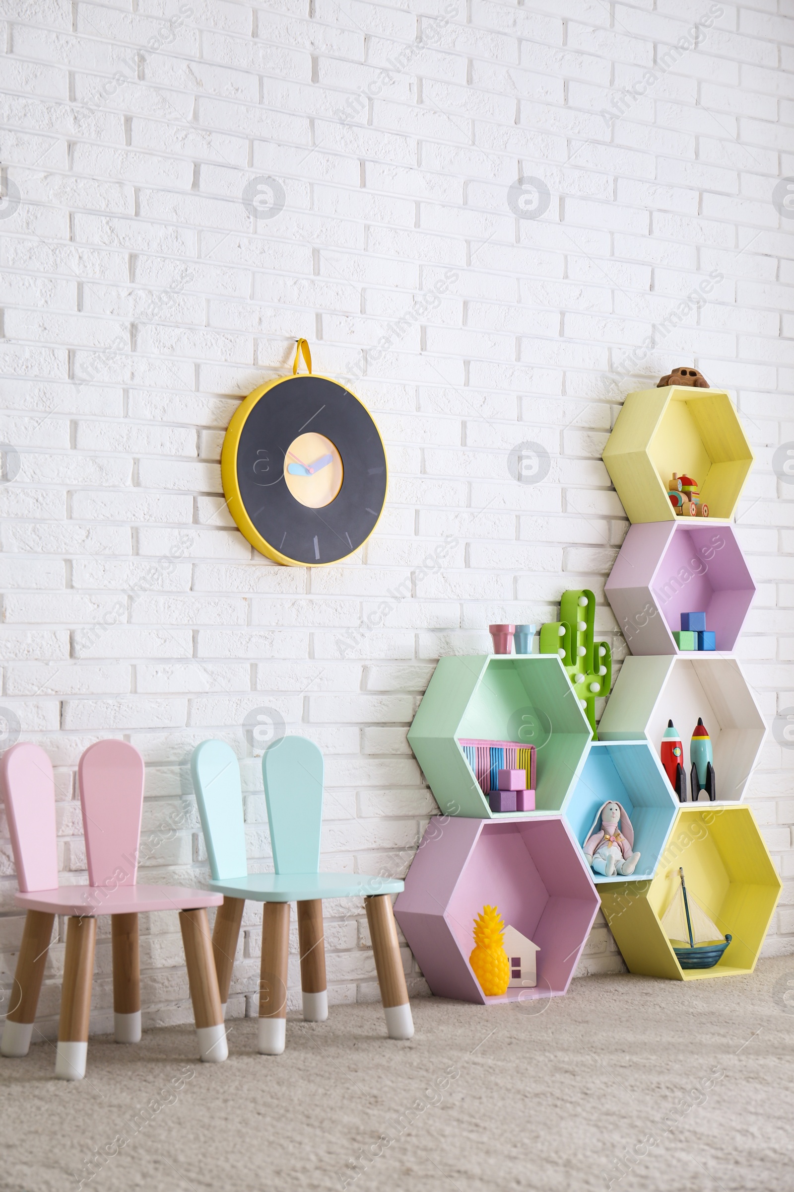 Photo of Child room interior with colorful shelves near brick wall