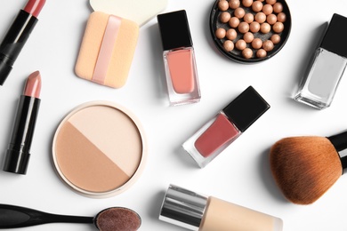 Flat lay composition with bottles of nail polish and different cosmetics on white background