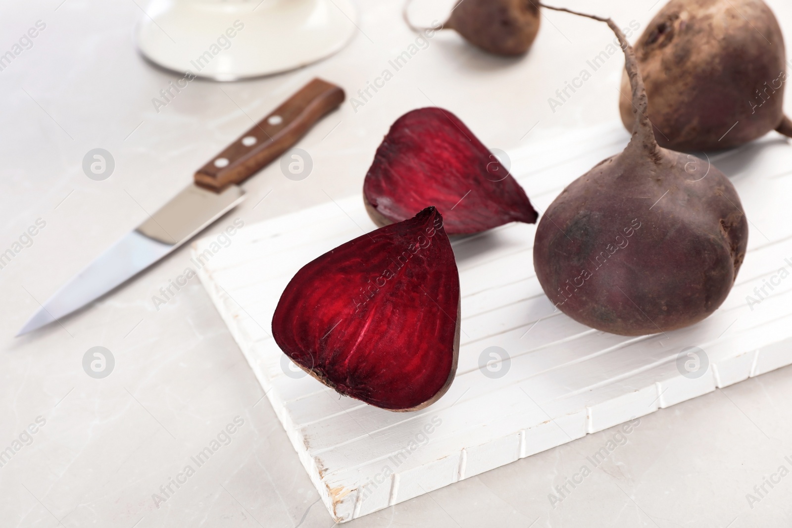 Photo of Wooden board with ripe beets on table