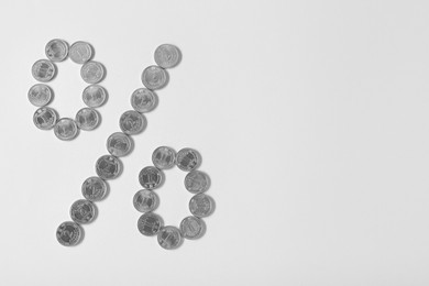 Percent sign made of Ukrainian hryvnia coins on light background, flat lay. Space for text