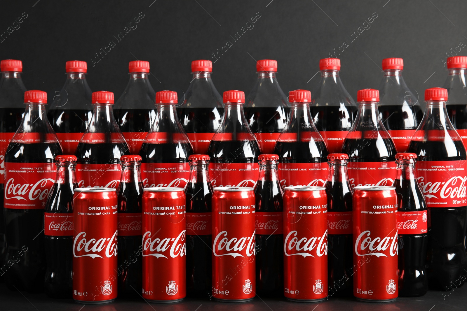 Photo of MYKOLAIV, UKRAINE - NOVEMBER 16, 2018: Bottles and cans with Coca-Cola on dark background