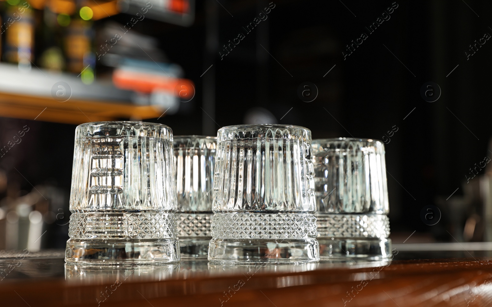 Photo of Empty clean glasses on counter in modern bar