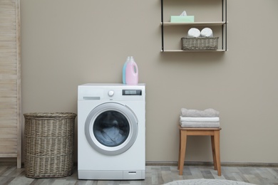 Photo of Washing machine with dirty towel in laundry room