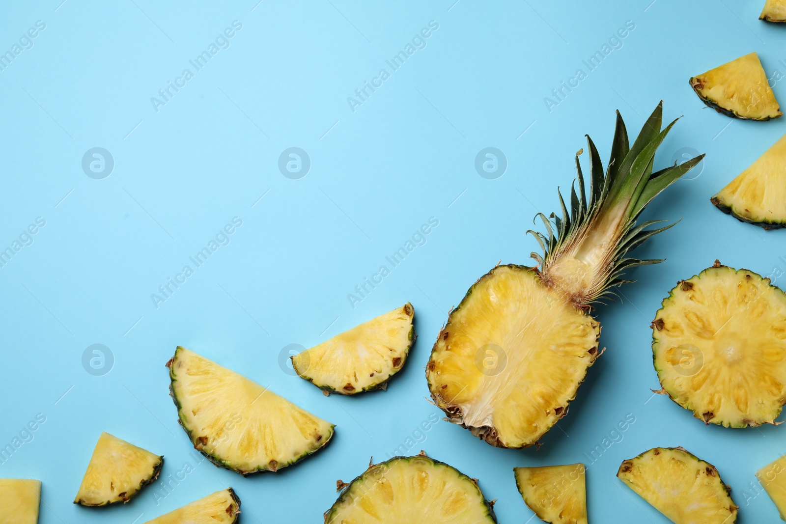 Photo of Flat lay composition with cut and fresh juicy pineapples on color background, space for text