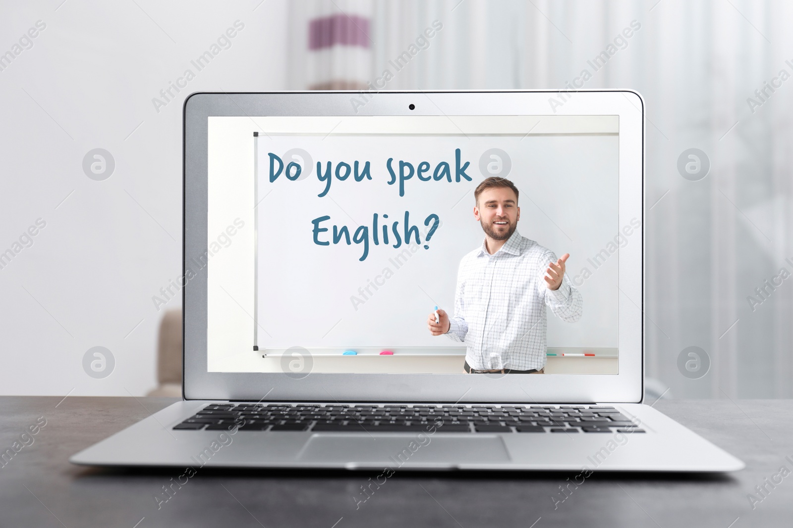 Image of Modern laptop for online English learning with teacher on table indoors