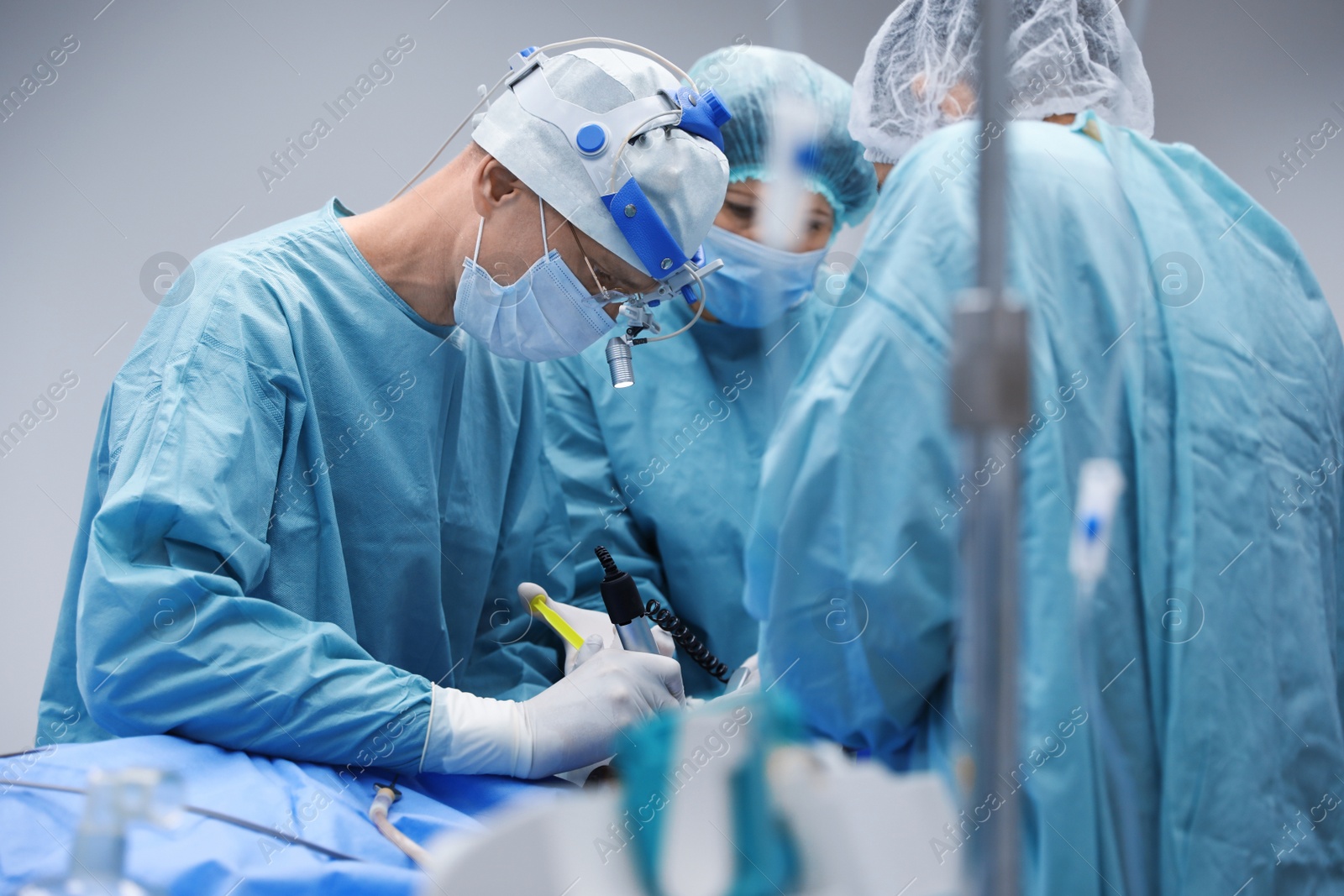 Photo of Team of professional doctors performing operation in surgery room