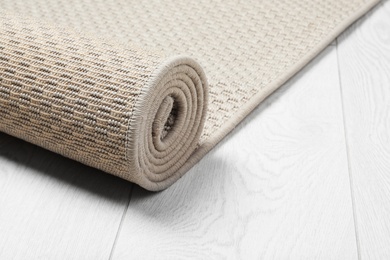 Rolled woven mat on wooden background. Space for text