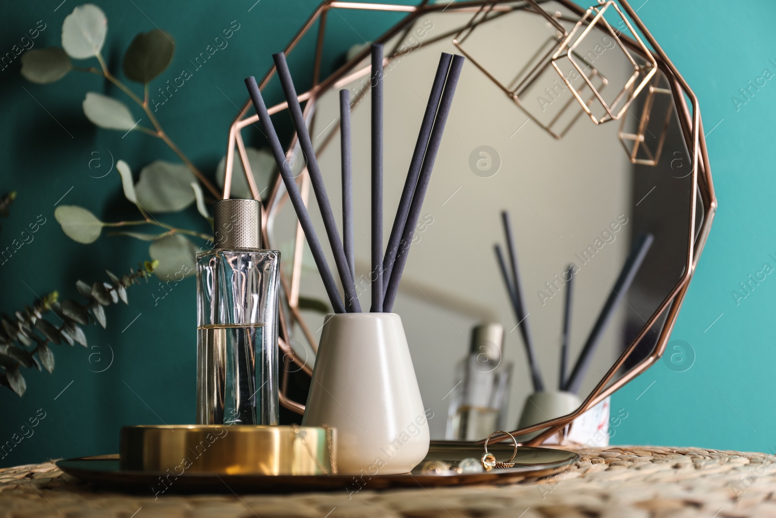 Photo of Composition with stylish accessories and interior elements on table near turquoise wall