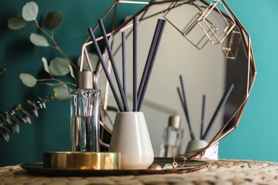 Composition with stylish accessories and interior elements on table near turquoise wall