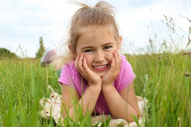 Cute little girl on blanket in field