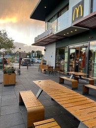 Photo of Leiden, Netherlands - October 15, 2023: Chairs and tables near McDonald's restaurant in city