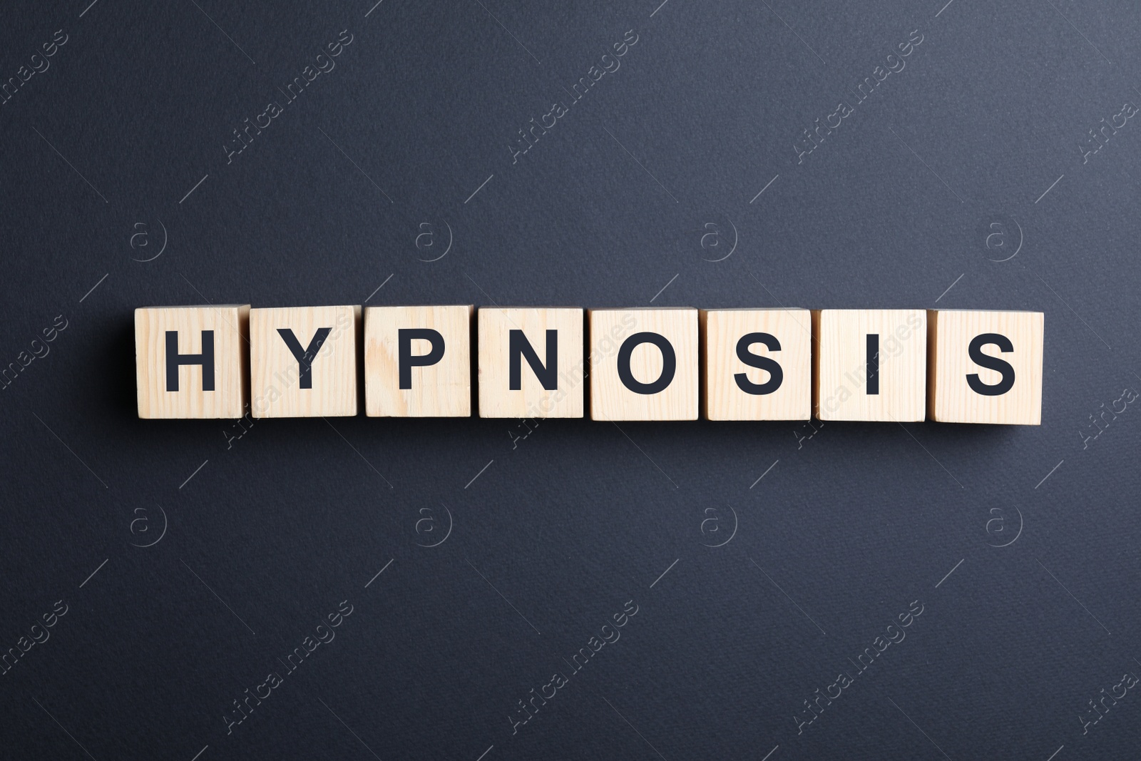 Photo of Wooden blocks with word HYPNOSIS on black background, flat lay