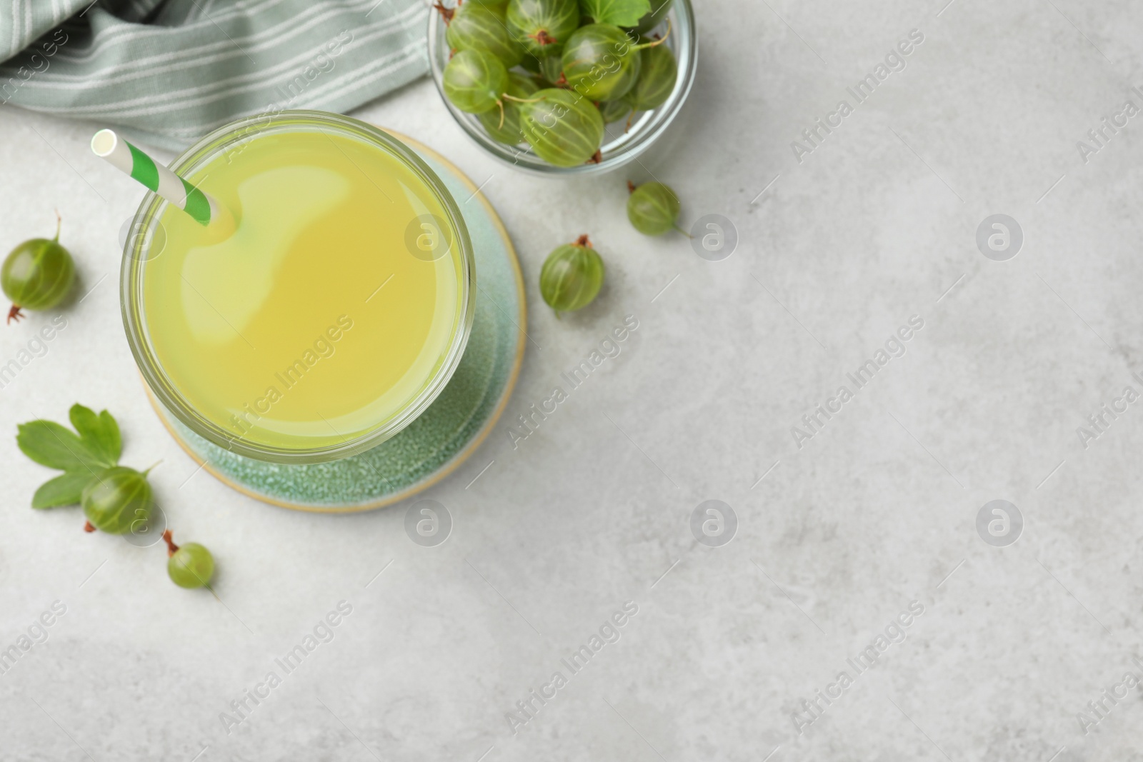 Photo of Tasty gooseberry juice and fresh berries on light table, flat lay. Space for text