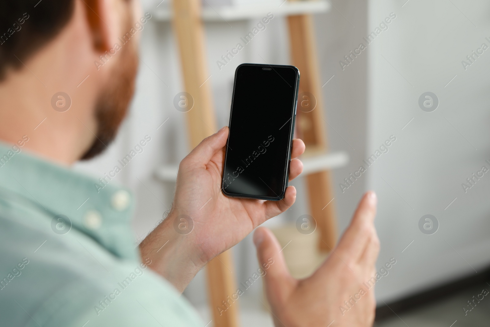 Photo of Man using smartphone at home, closeup view. Space for text