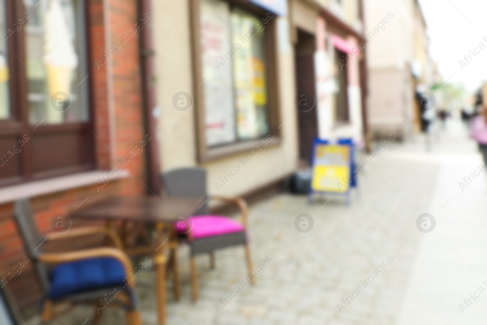 Photo of Blurred view of outdoor cafe with chairs and table