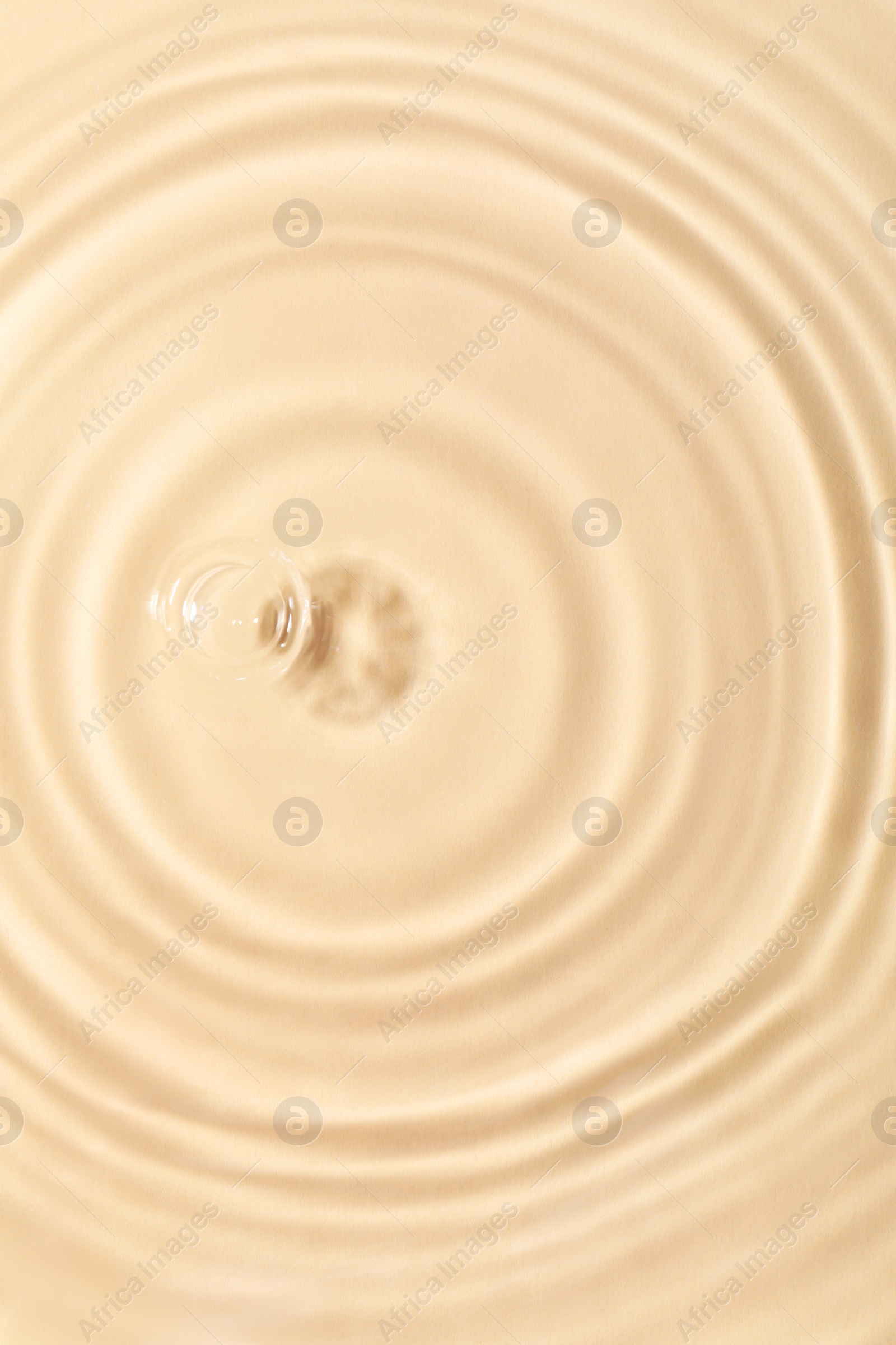Photo of Closeup view of water with rippled surface on beige background