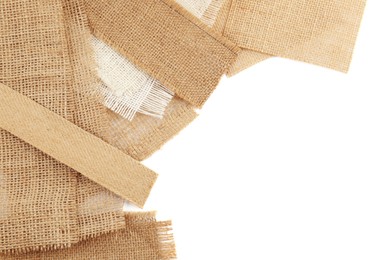 Photo of Pieces of burlap fabric isolated on white, top view