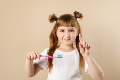 Photo of Little girl with toothbrush on color background. Teeth care