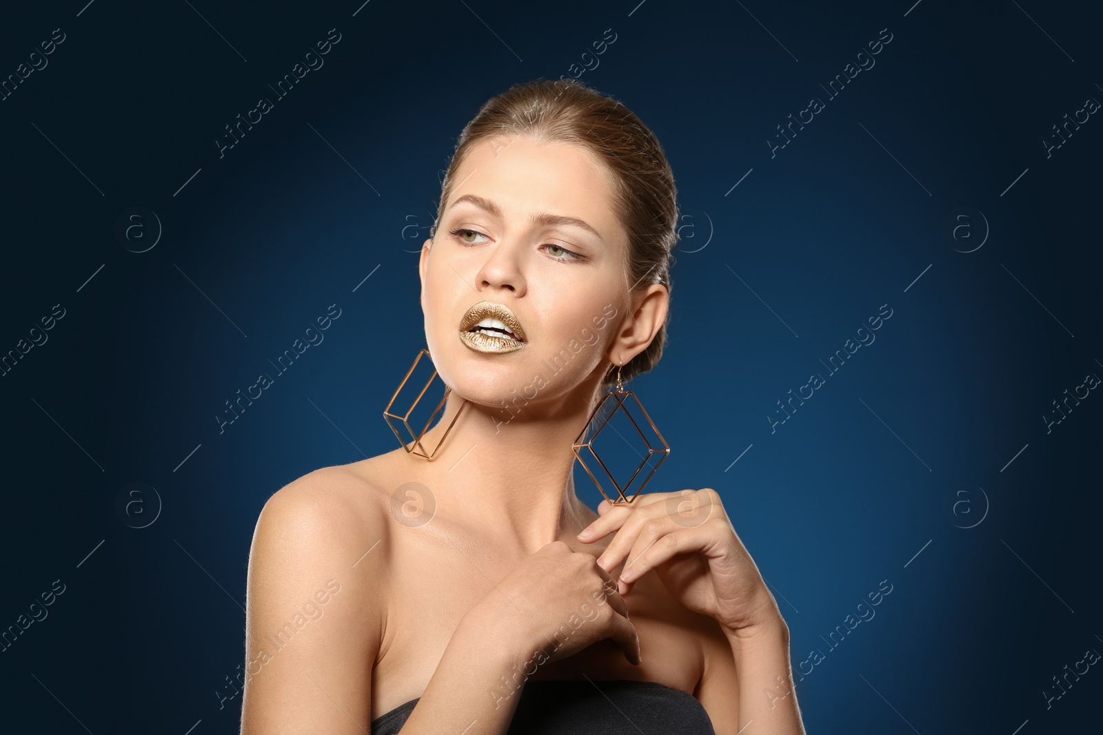 Photo of Portrait of beautiful lady with gold lipstick on color background