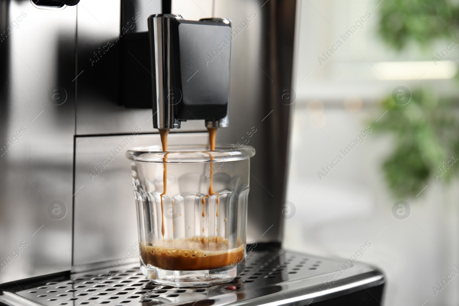 Photo of Espresso machine pouring coffee into glass against blurred background, closeup. Space for text