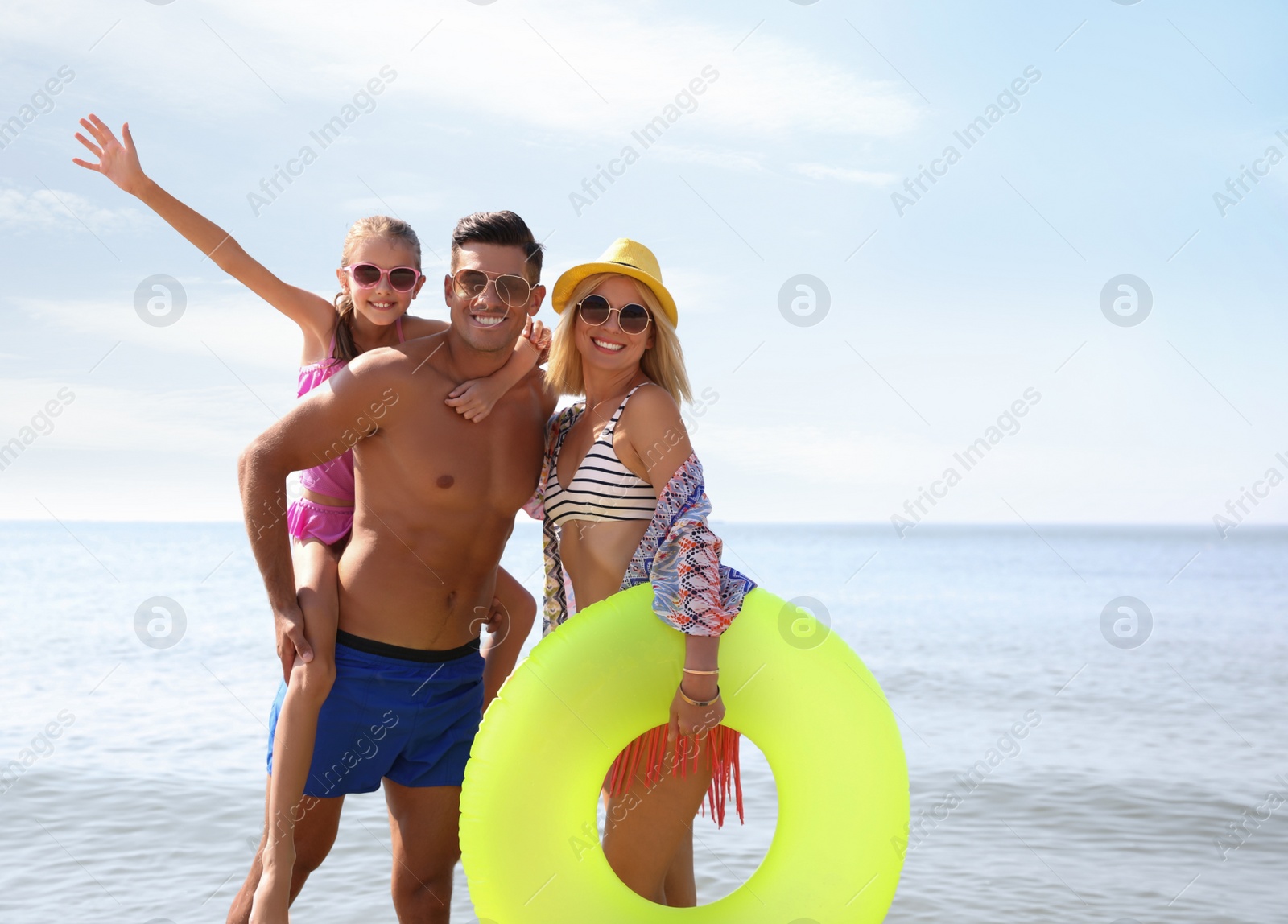 Photo of Happy family with inflatable ring at beach on sunny day