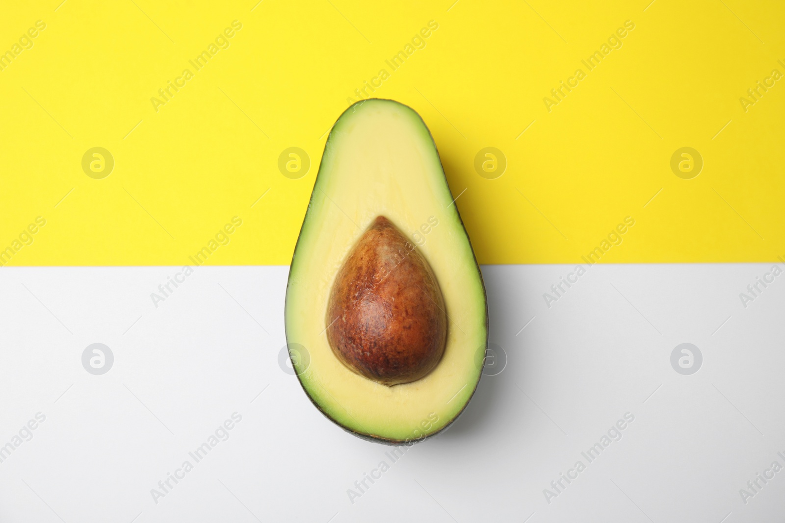 Photo of Cut fresh ripe avocado on color background, top view