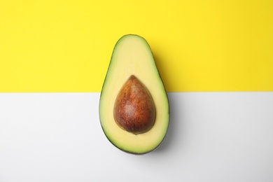 Cut fresh ripe avocado on color background, top view