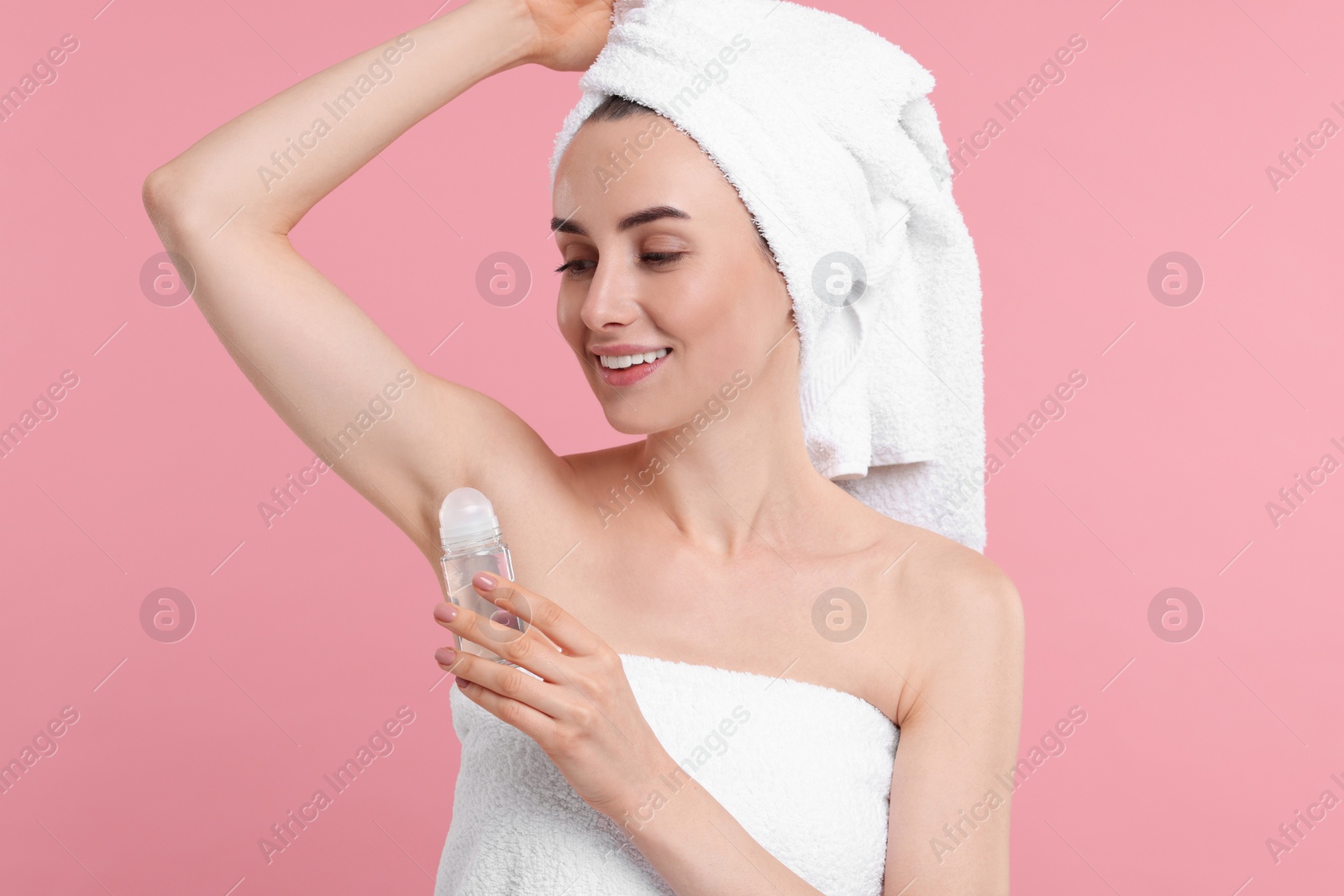 Photo of Beautiful woman applying deodorant on pink background