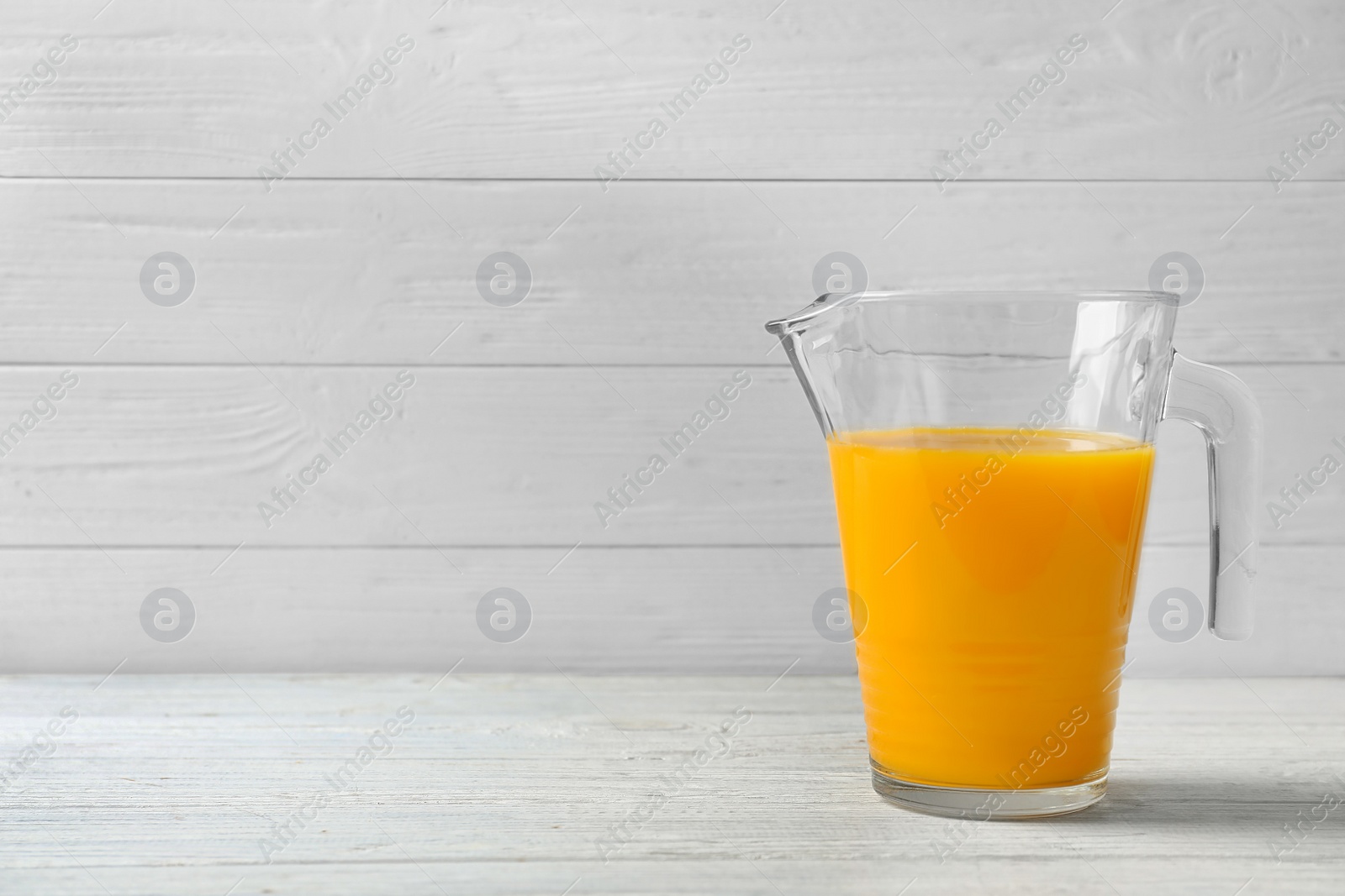 Photo of Jug with orange juice on table