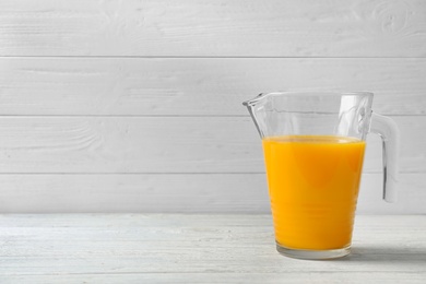 Photo of Jug with orange juice on table